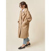 Woman wearing a beige coat on a plain background