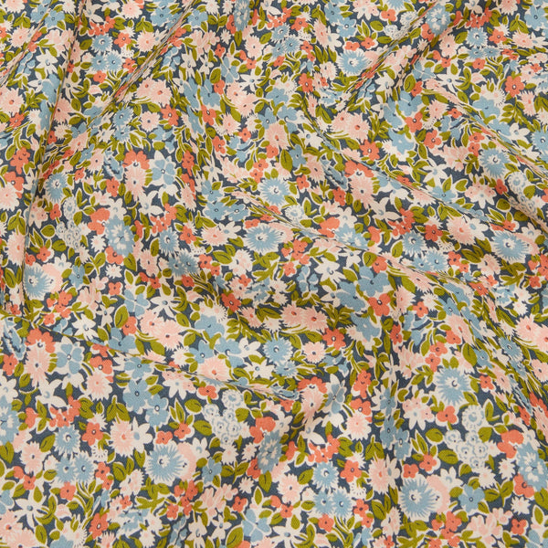 Floral fabric pattern with small flowers in pink, blue, and green on a dark background