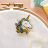 Colorful unicorn pin on a embroidery hoop with pink background