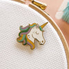 Colorful unicorn pin on a white fabric background